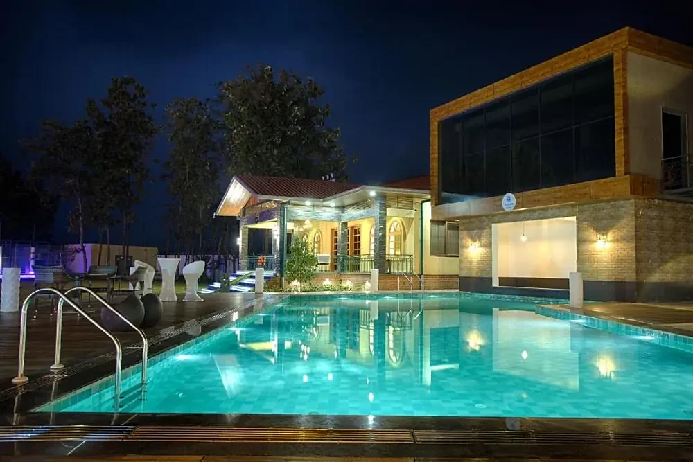 Resort swimming pool and palm lawns at Four Vedas, Siliguri